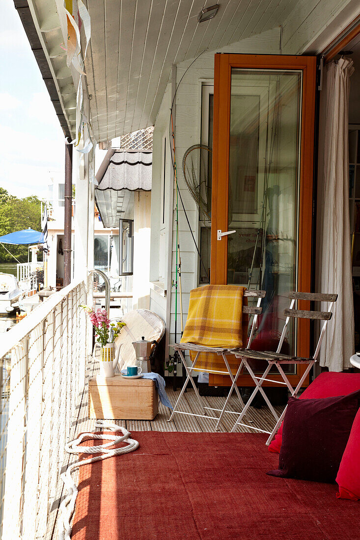 Folding chairs on veranda of houseboat in Richmond upon Thames, England, UK