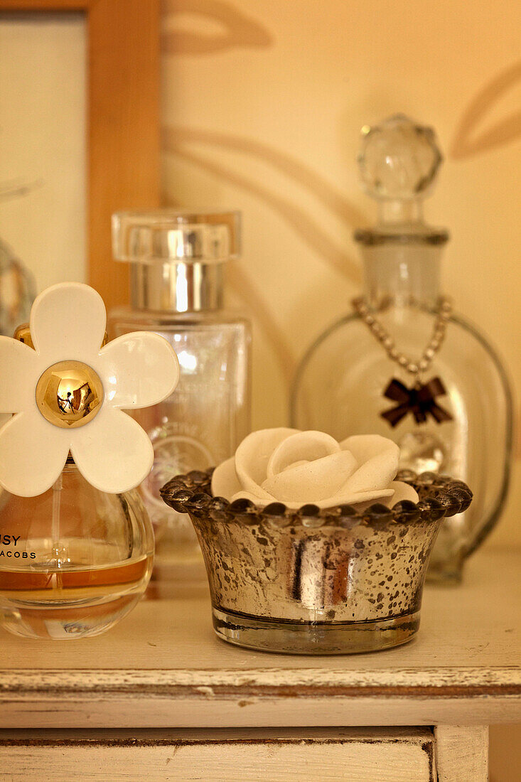 Perfume bottles and silver tea light holder in West Sussex home, England, UK