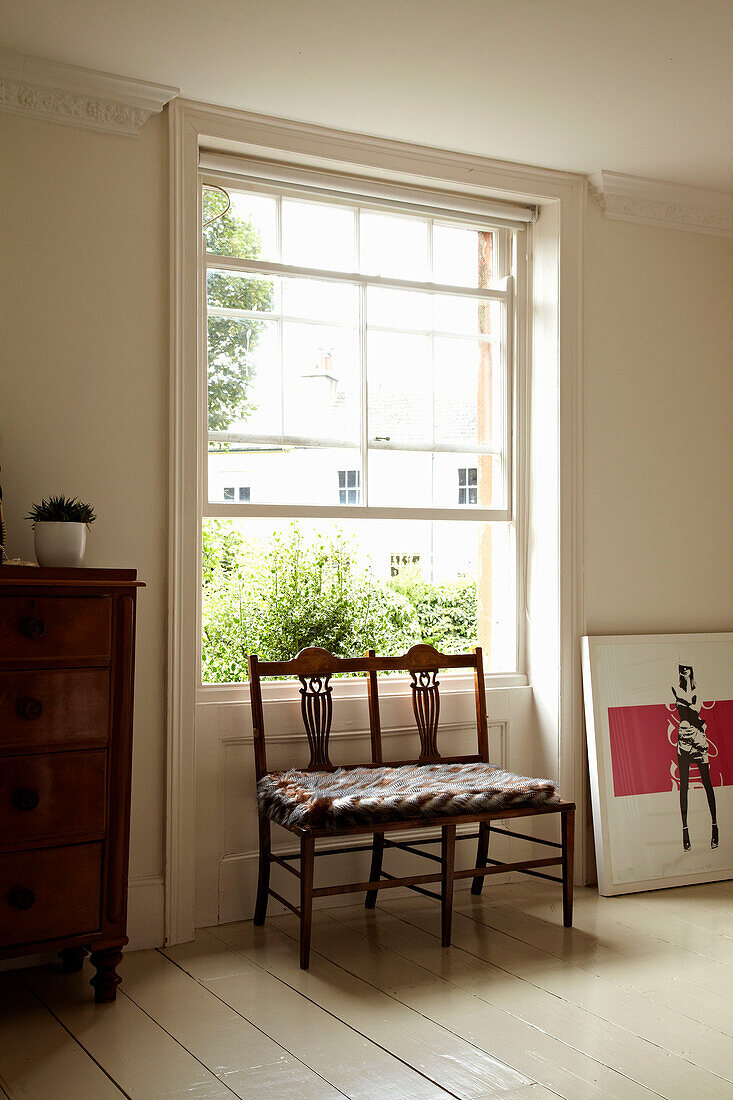 Double seat at open sash window in bedroom of Brighton townhouse, Sussex, England, UK