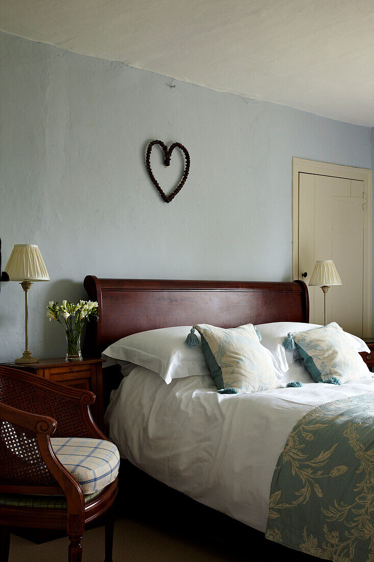 Herz über einem Holzbett in einem Haus in West Sussex, England, UK