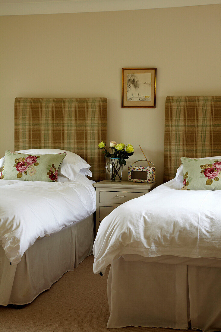 Cut roses and twin beds in West Sussex home, England, UK