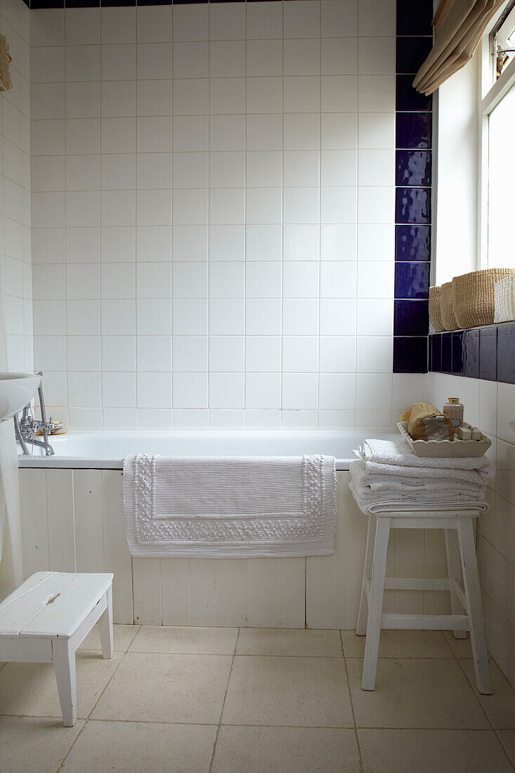 White tiled bathroom with blue surround London