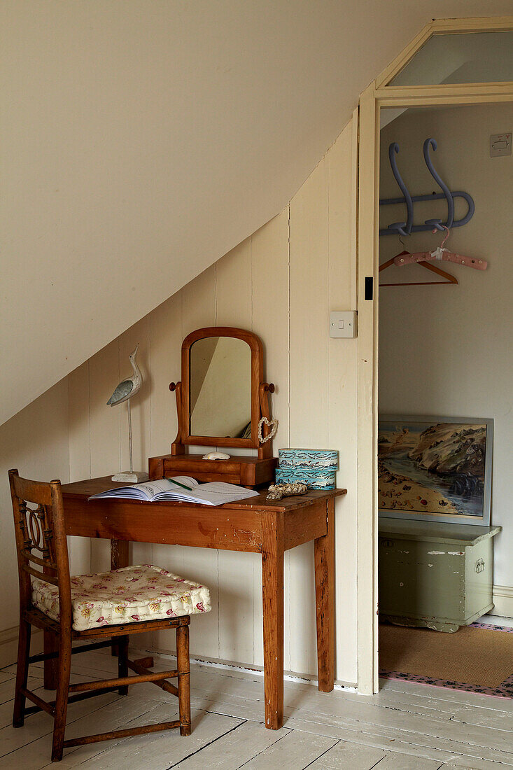 Desk and chair under slanted ceiling in Norfolk beach house, UK
