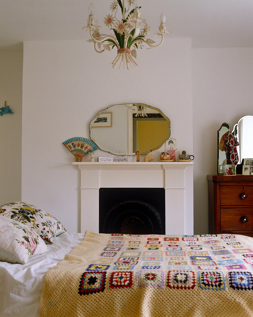 Doppelbett mit gehäkelter Tagesdecke vor dem Kamin in einem Schlafzimmer im traditionellen Stil