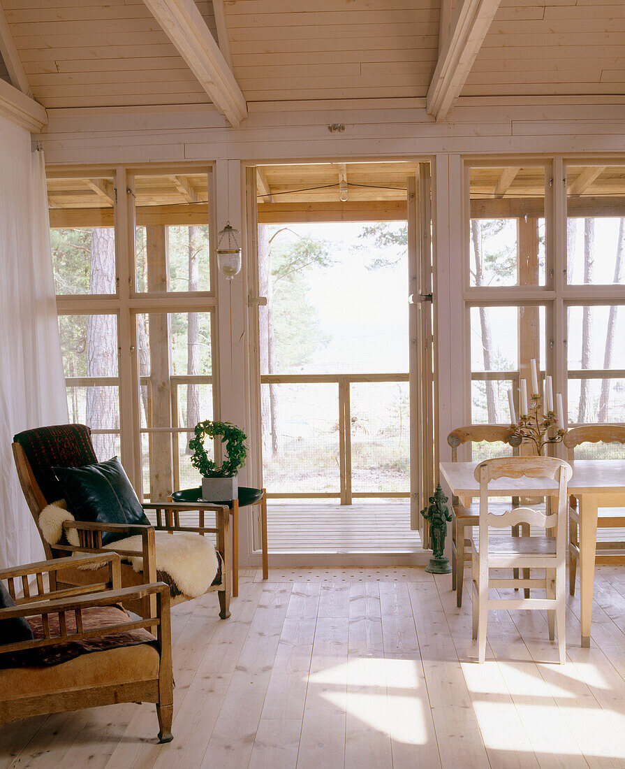 Wohnzimmer im Landhausstil mit Holzfußboden und einer Veranda mit Fenstern und Terrassen