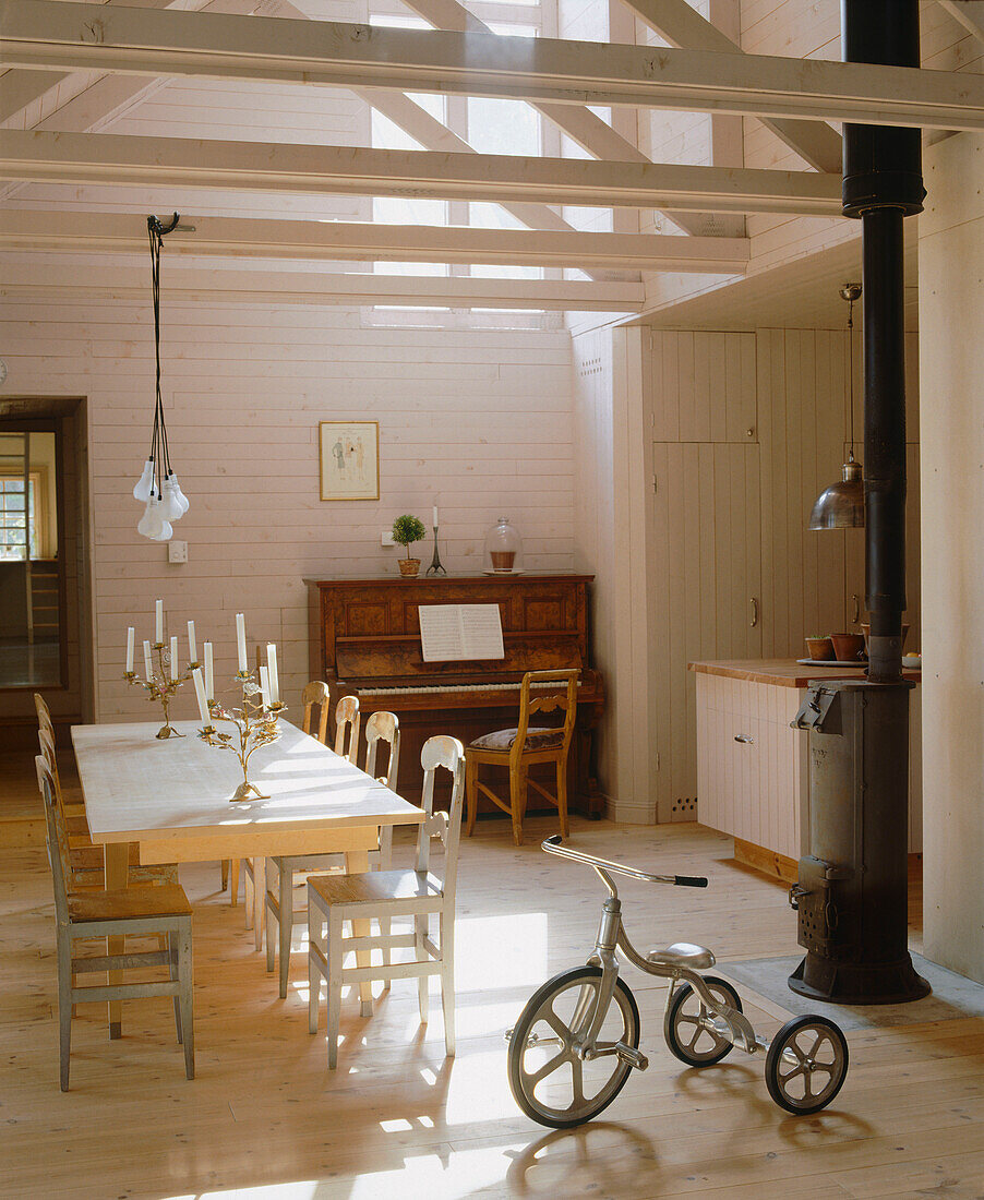 Esszimmer im Landhausstil mit einem Dreirad neben einem großen Esstisch aus Holz