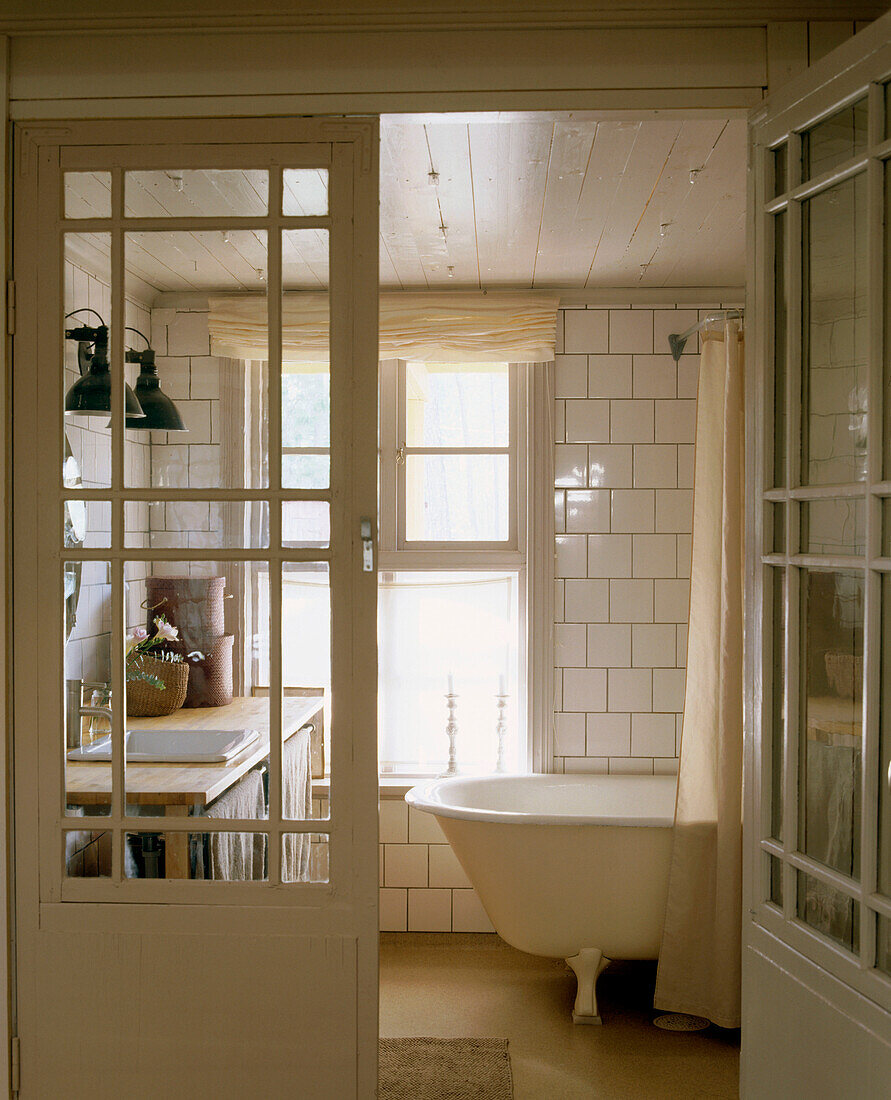 Badezimmer im Landhausstil mit weißen Fliesen und einer freistehenden Badewanne aus der Zeit