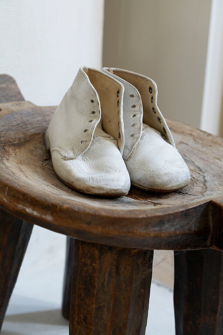 Pair of child's old fashioned shoes on wooden stool