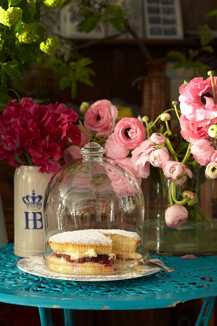 Victoria sponge cake with cut flowers in Lincolnshire home, England, UK