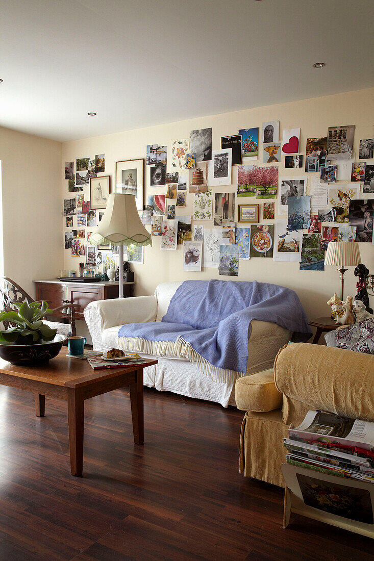 Sofa im Wohnzimmer mit fliederfarbenem Überwurf darüber Bildersammlung in einem Haus in Lincolnshire, England, UK