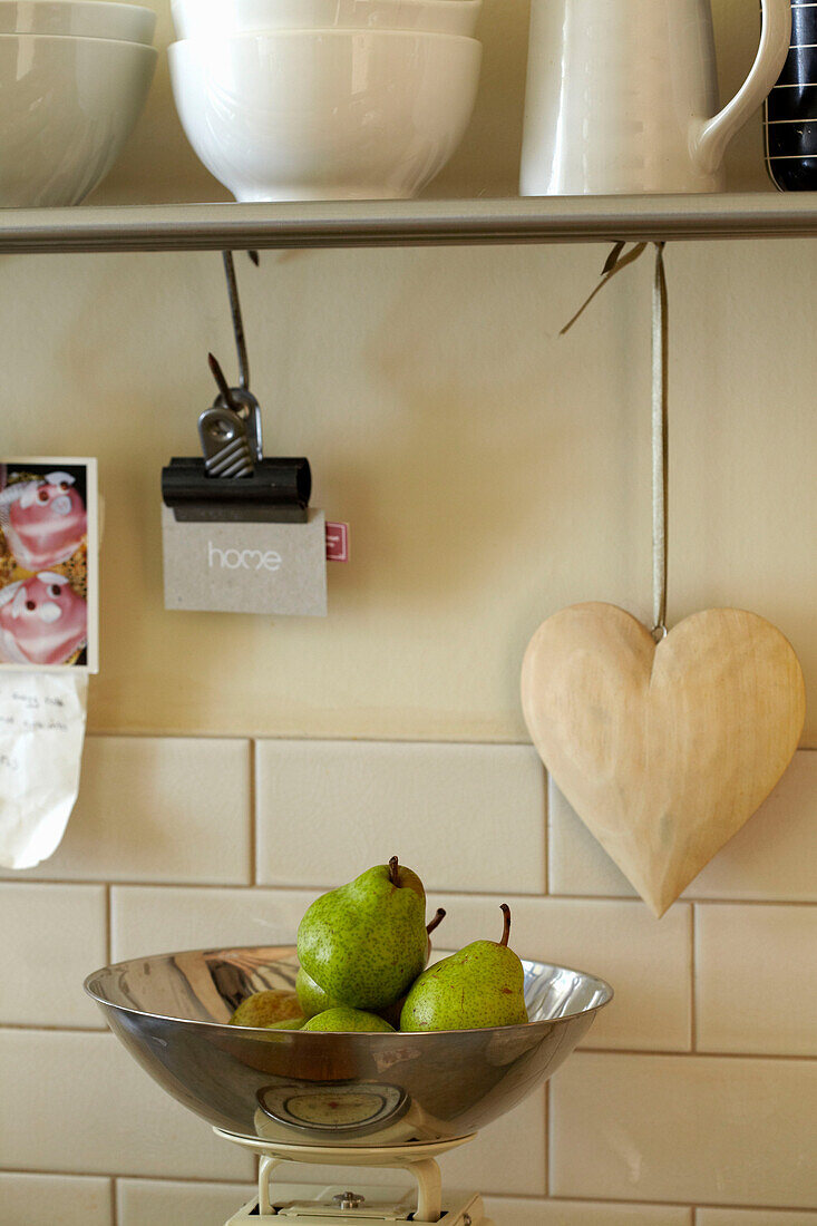 Heart shaped ornament and pears on kitchen scales in Brighton home, East Sussex, England, UK