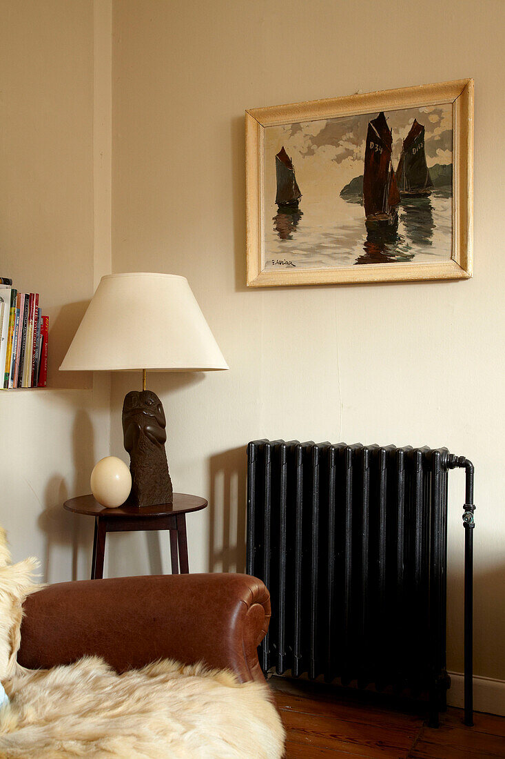 Schwarzer Vintage-Heizkörper unter einem Gemälde in einem Haus in Brighton, East Sussex, England, UK