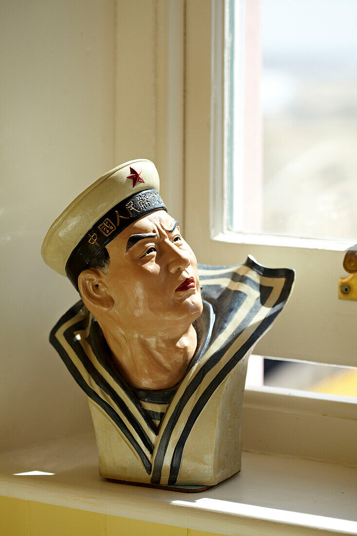 Seemannsstatue auf der Fensterbank eines Strandhauses in Cromer, Norfolk, England, UK