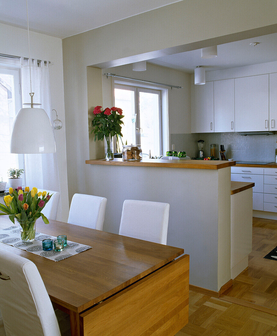 Wooden table and upholstered chairs in open plan kitchen
