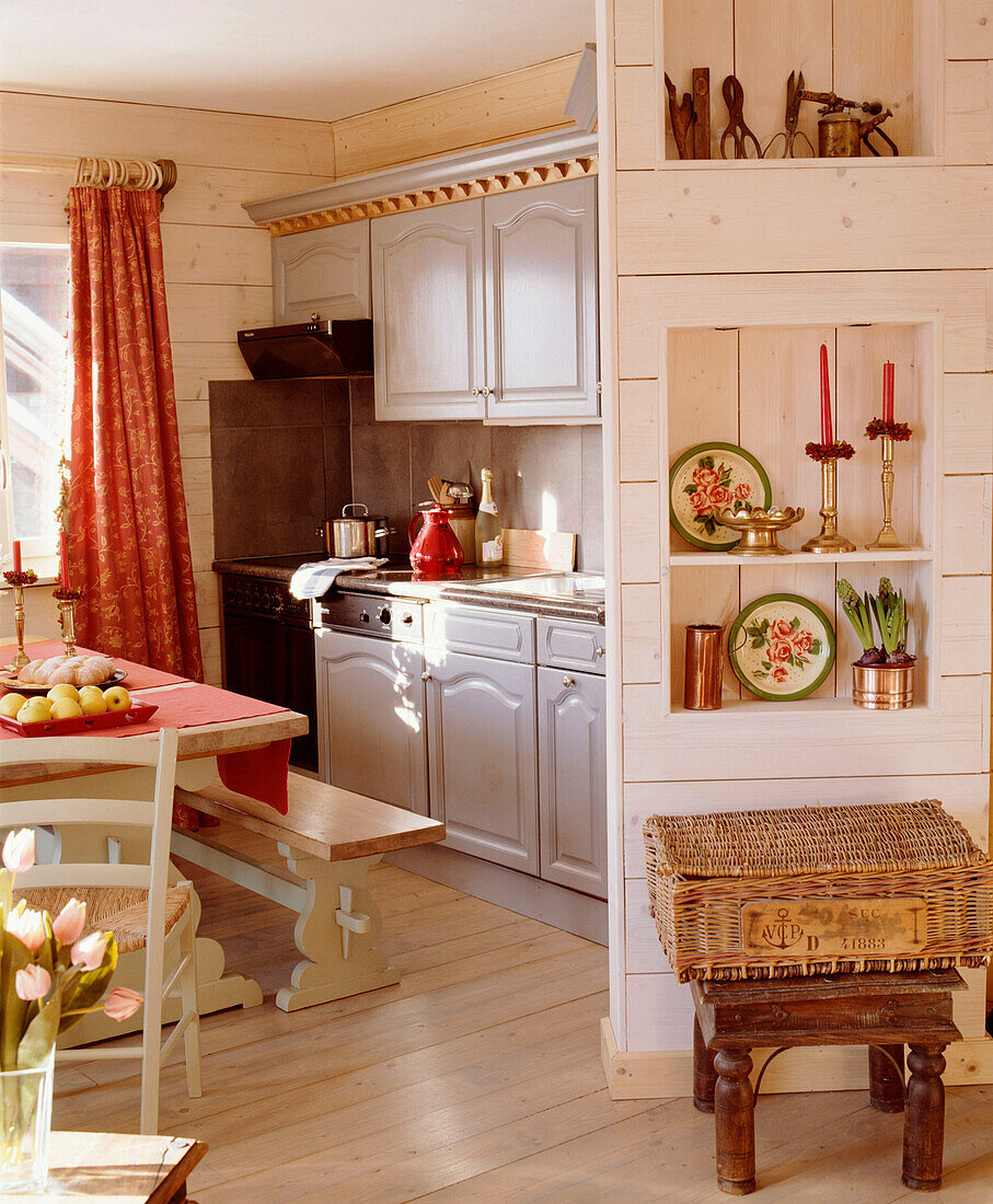 Offene Küche im Landhausstil mit Essecke, Holzvertäfelung, Holztisch, Sitzbank, Holzboden und Regalkörben