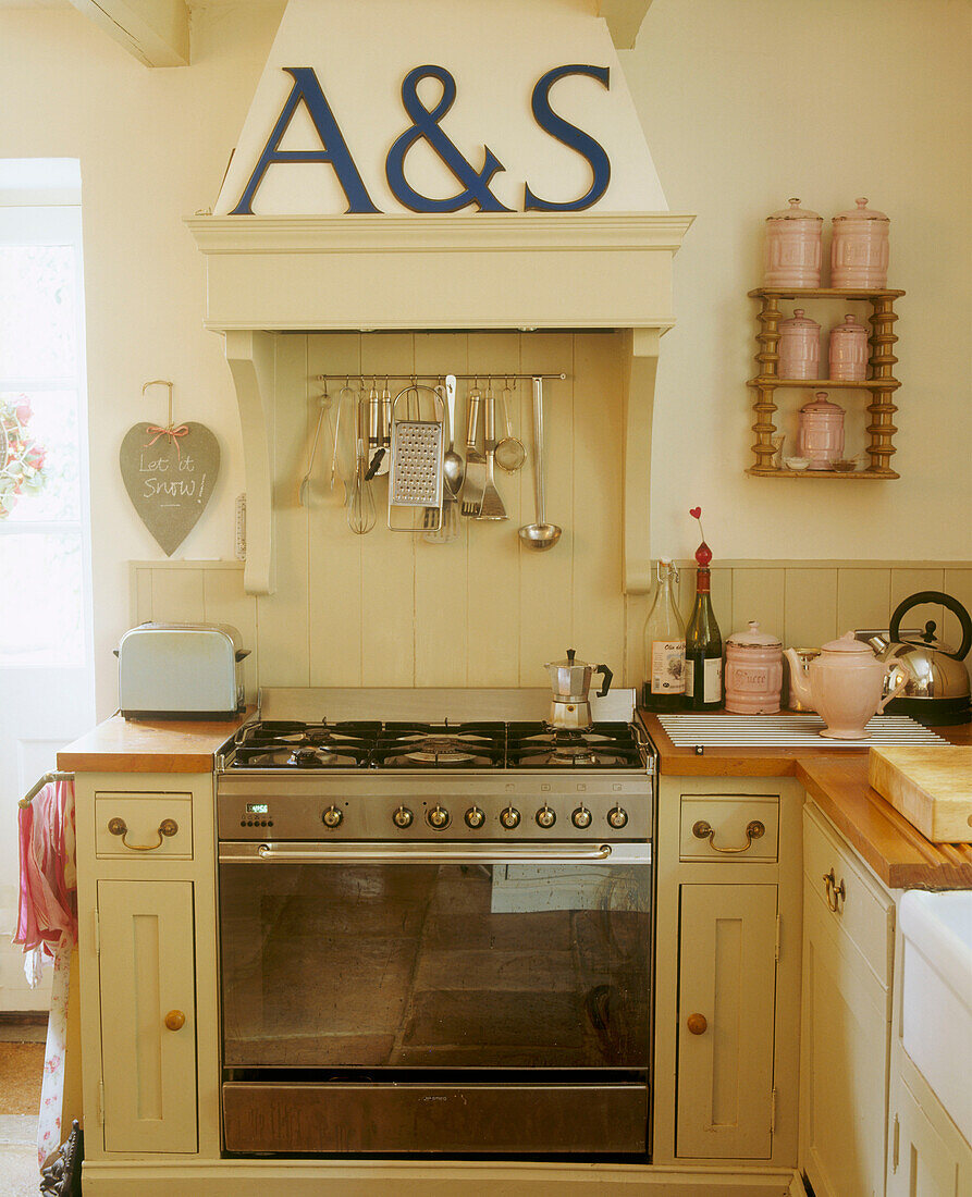 Country kitchen oven wood panelling fitted unit and capital A&S letters on the wall
