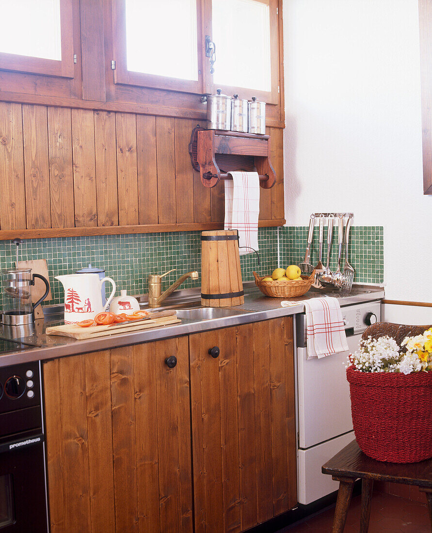 Eine rustikale Landhausküche mit Holzvertäfelung und Edelstahlspüle