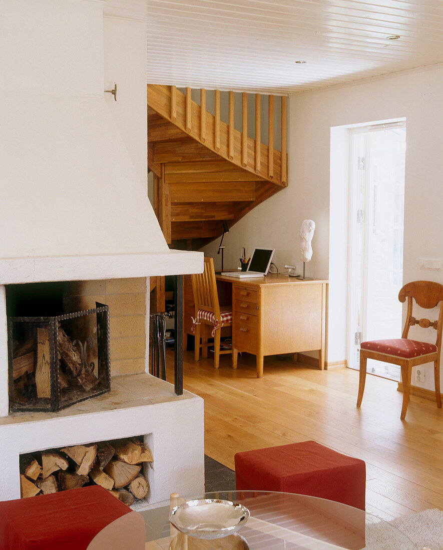Wohnzimmer mit einem eingebauten Eckkamin und einer Holztreppe im Hintergrund