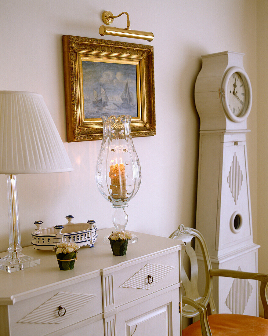 Gustavianische Uhr neben Stuhl und Anrichte in einem Zimmer im schwedischen Stil