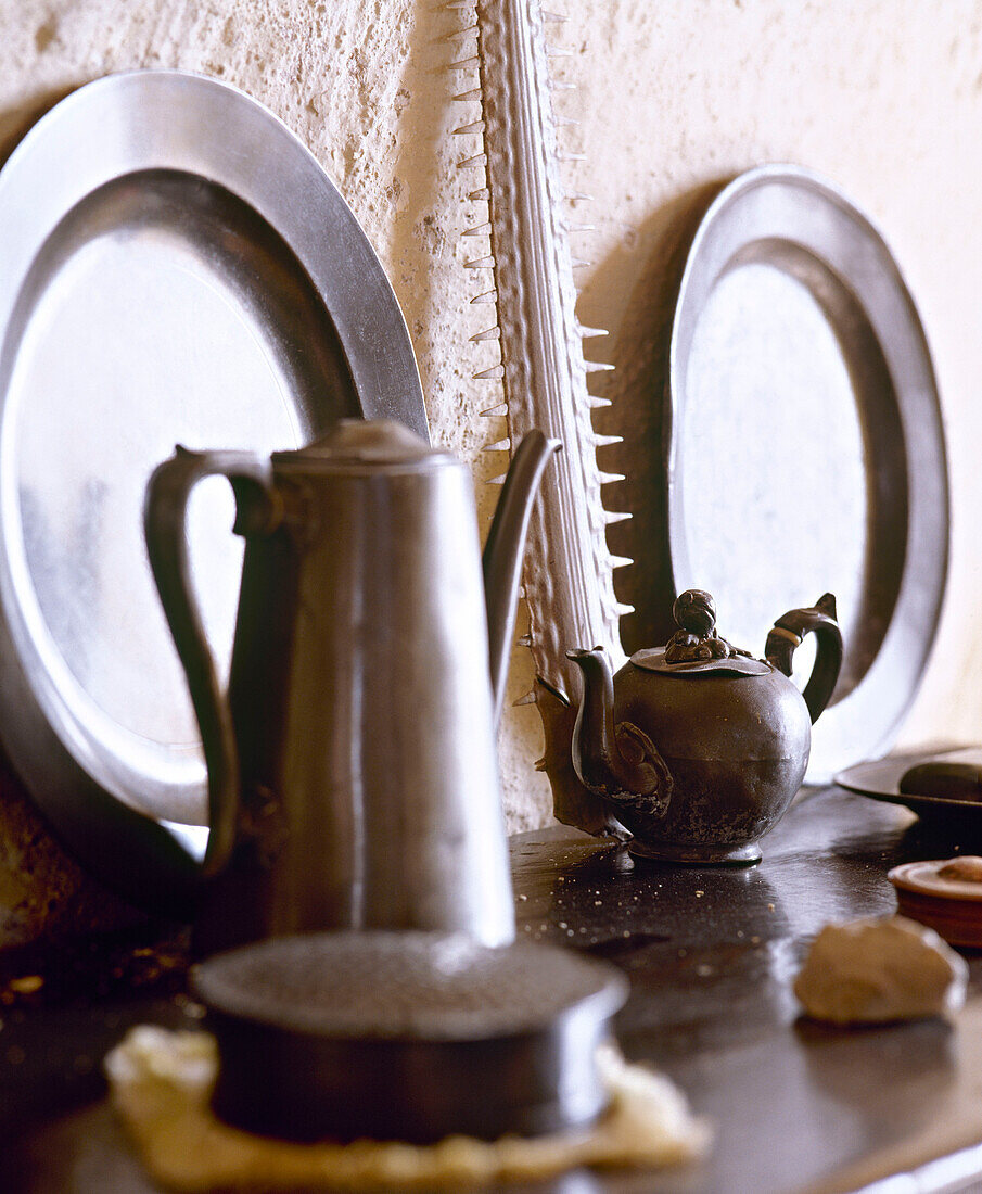 Pewter plates and coffee pot on shelf
