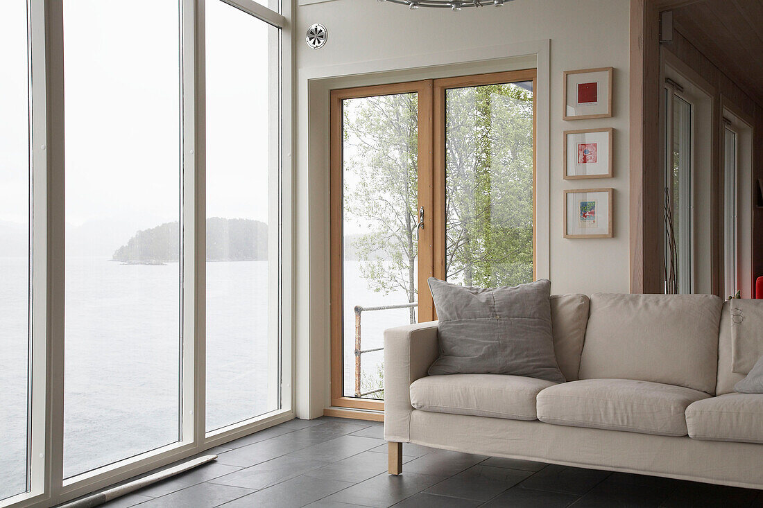Contemporary sofa in bay window overlooking lake