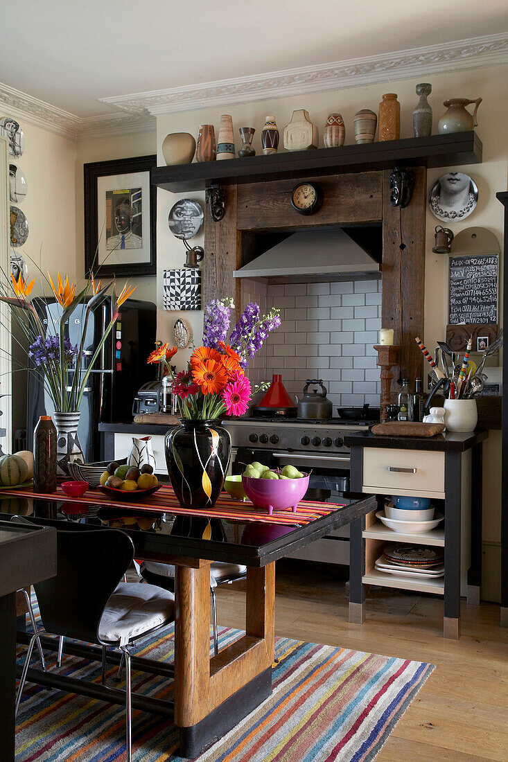 Flower arrangement and bowls of fruit of polished table in contemporary kitchen