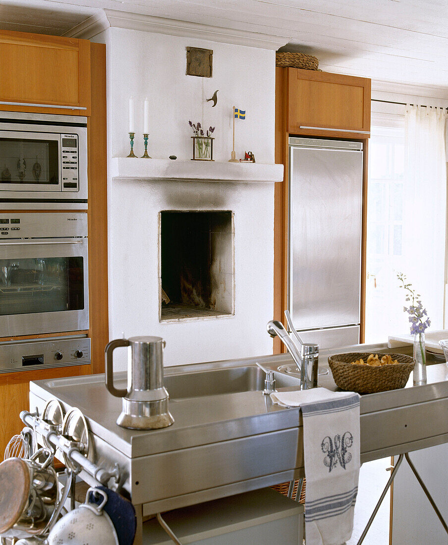 Edelstahl-Spüle dahinter eingebaute Küchengeräte auf beiden Seiten eines Kamins
