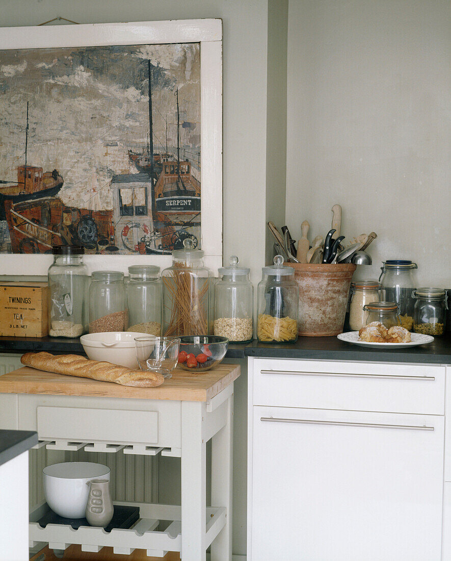 Küche mit Gläsern auf der Arbeitsfläche und Gemälde an einer Wand