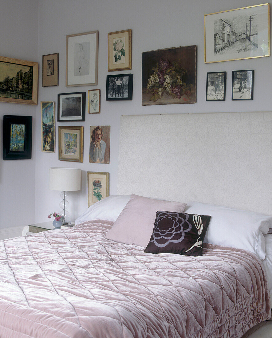 Doppelbett mit rosa Bettdecke und Nachttisch