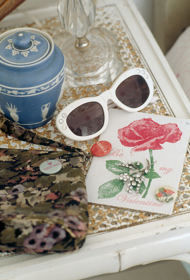 Greeting card sunglasses and blue ceramic pot on bedside table