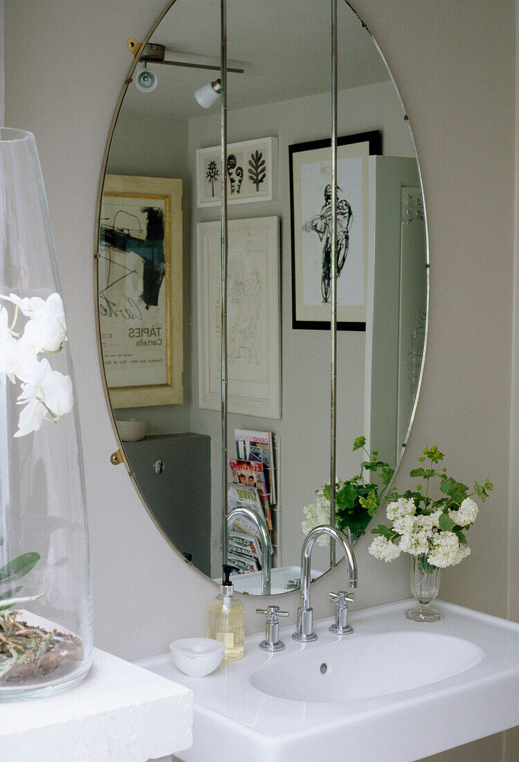 Washbasin below an oval mirror