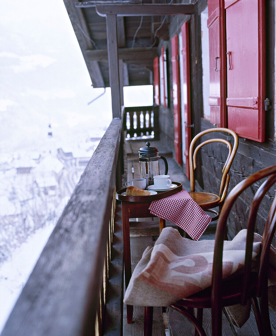 Außenansicht eines schweizer Chalets mit Stühlen auf dem Balkon
