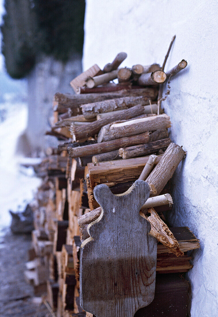 Detail eines Stapels gehackter Holzscheite vor einem schweizer Chalet