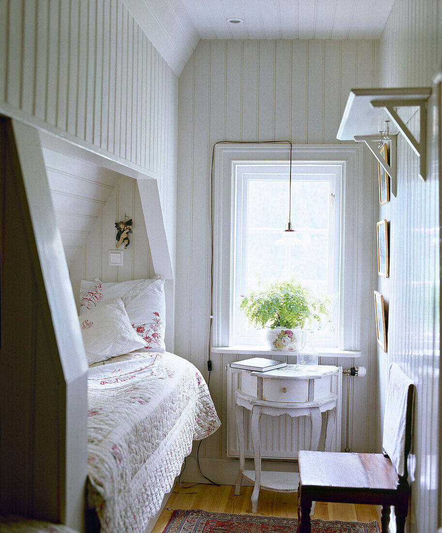 Gustavianischer Beistelltisch neben dem Kabinenbett in einer Nische in einem Schlafzimmer im Landhausstil