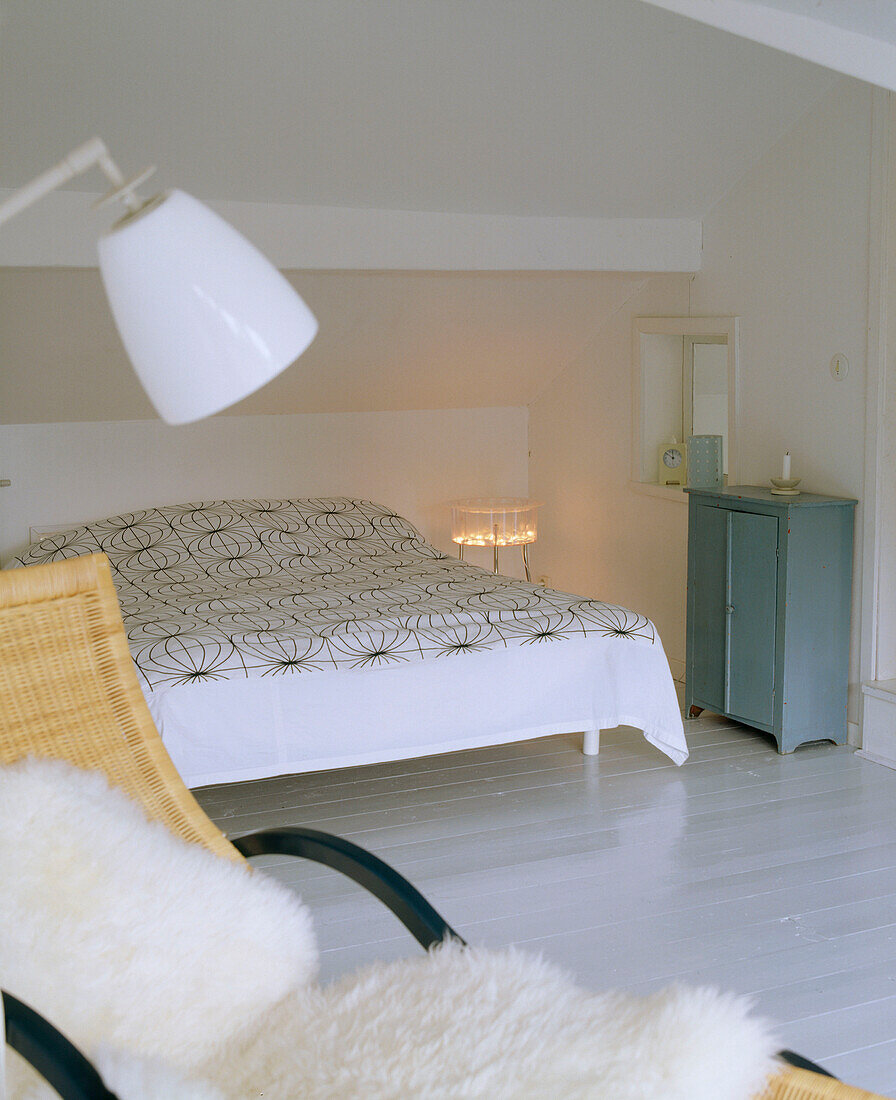 Schlafzimmer mit einer Lampe und einem Sessel im Vordergrund