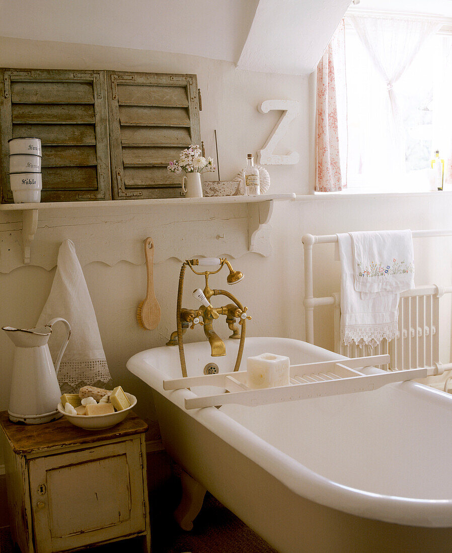 Badezimmer im Landhausstil in neutralen Farben mit freistehender Badewanne, Krug, Schrank, Heizkörper und Handtuchhalter