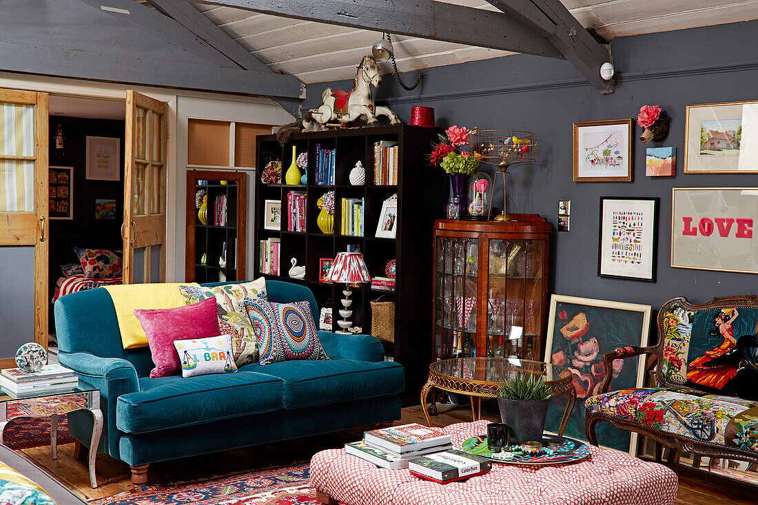 Tealfarbenes Sofa und Bücherregal in einer umgebauten Scheune in Brighton, East Sussex UK