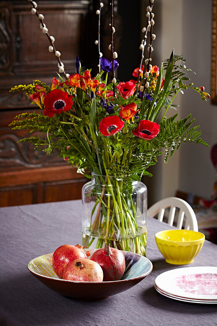 Mohnblumen und Granatäpfel auf einem Tisch in einem Haus in Brighton, East Sussex, Großbritannien