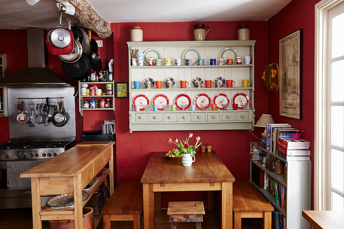 Wandschrank mit Holzmöbeln und Edelstahlofen in der Küche eines Hauses in Bridport, Dorset, Großbritannien