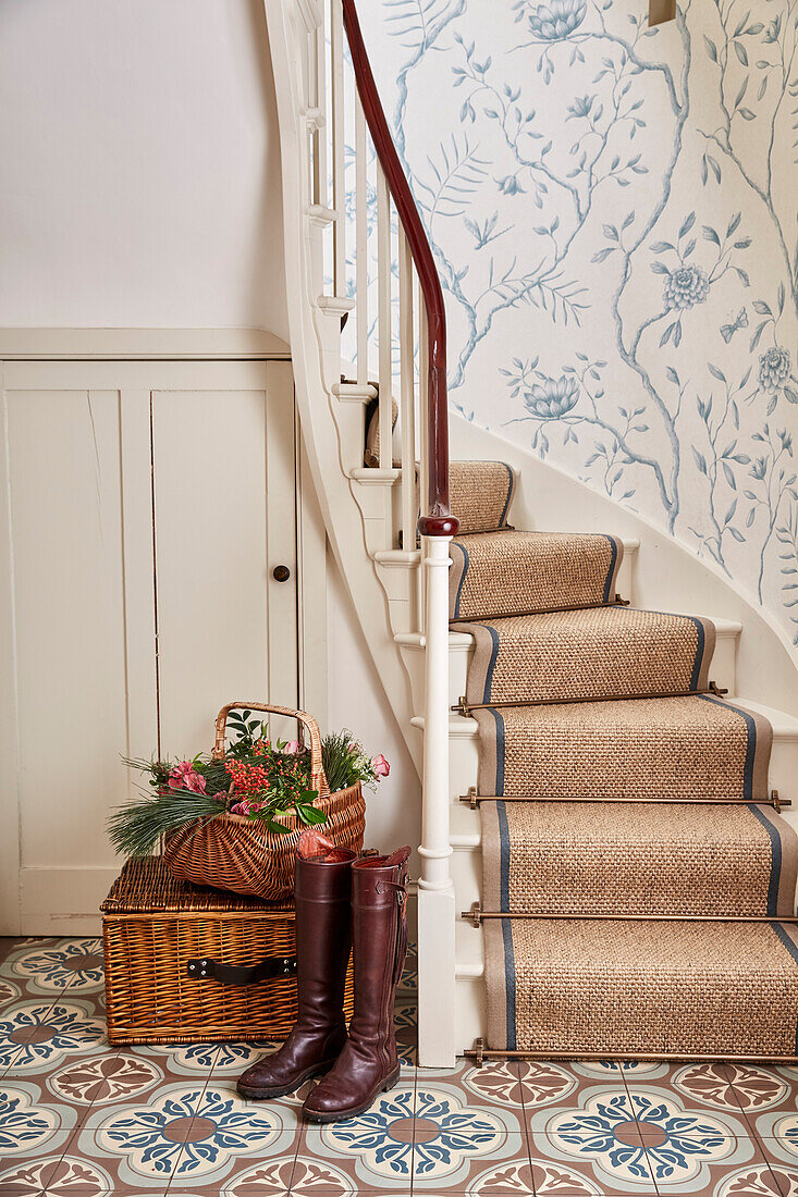 Ornament-Bodenfliesen, Treppe mit Mahagoni-Handlauf und Jasper Peony-Tapete im Flur eines unter Denkmalschutz stehenden Bauernhauses in Kent, Großbritannien