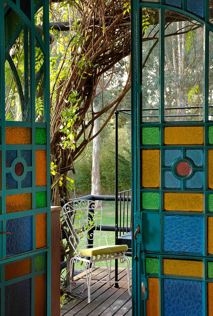 View of wrought iron garden furniture through stained glass doors