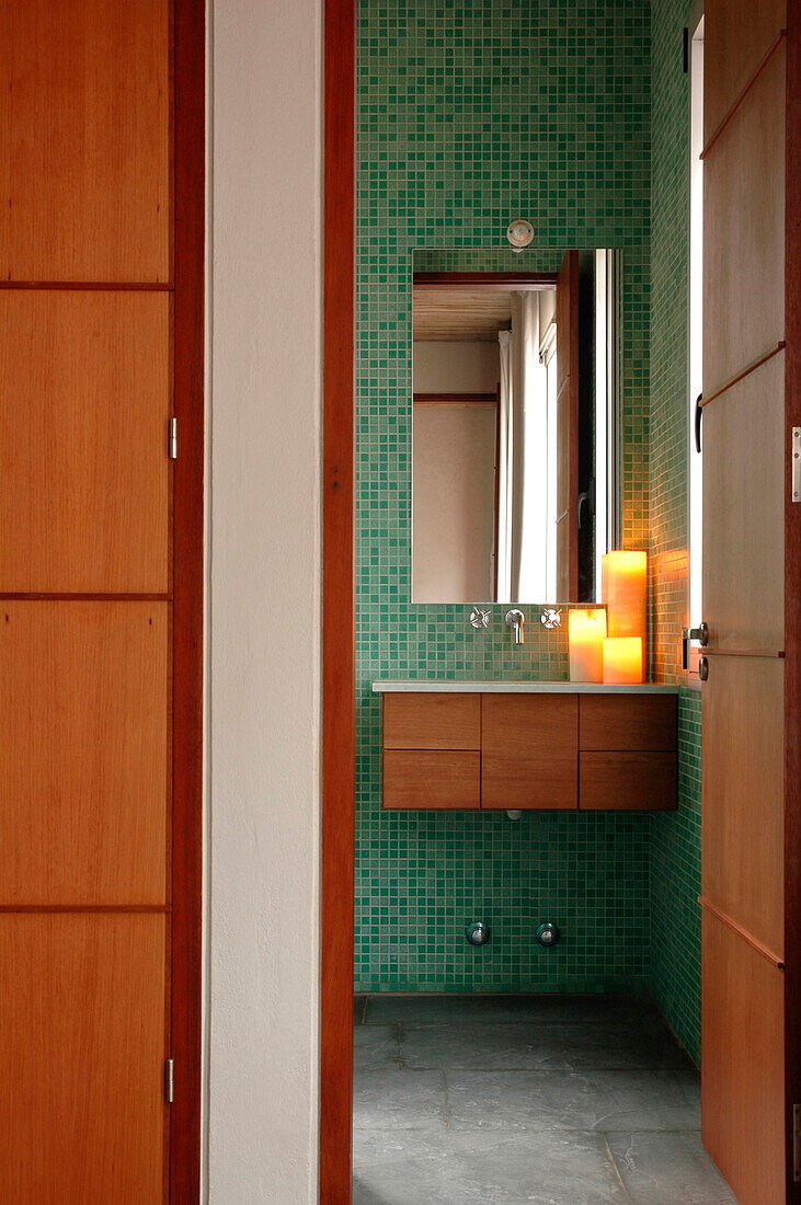 Drawer unit below en suite sink with mirror viewed through doorway