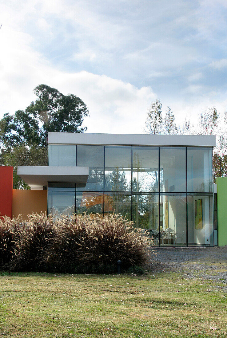 Fassade eines Glaskubus-Hauses mit Farbflächen im Brutalismus-Minimalismus-Stil
