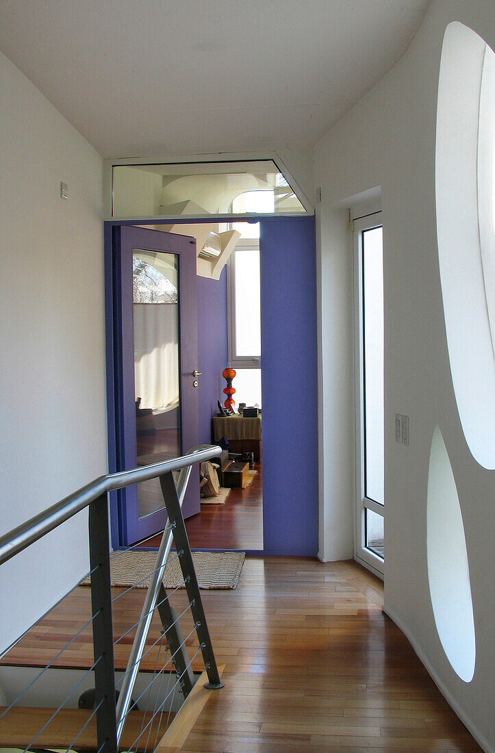 Purple doorway leading from wooder staircase of red eucalyptus