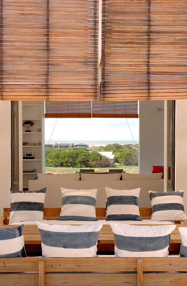 Terrace with blue and white striped cushions and roller blinds reflected view