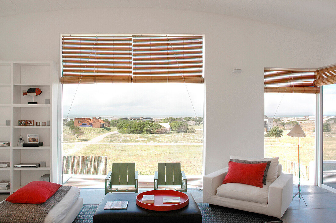 Living room with view of sea with touches of green and red