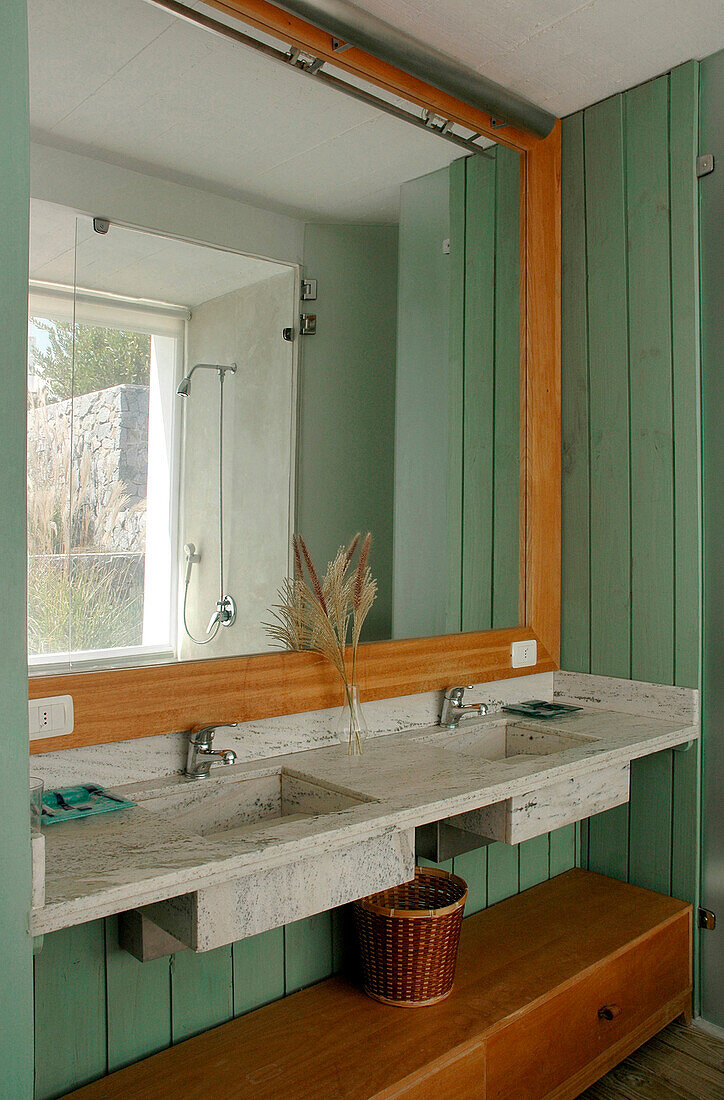 Grün getäfeltes Badezimmer mit Doppelwaschbecken und Zedernholzkasten