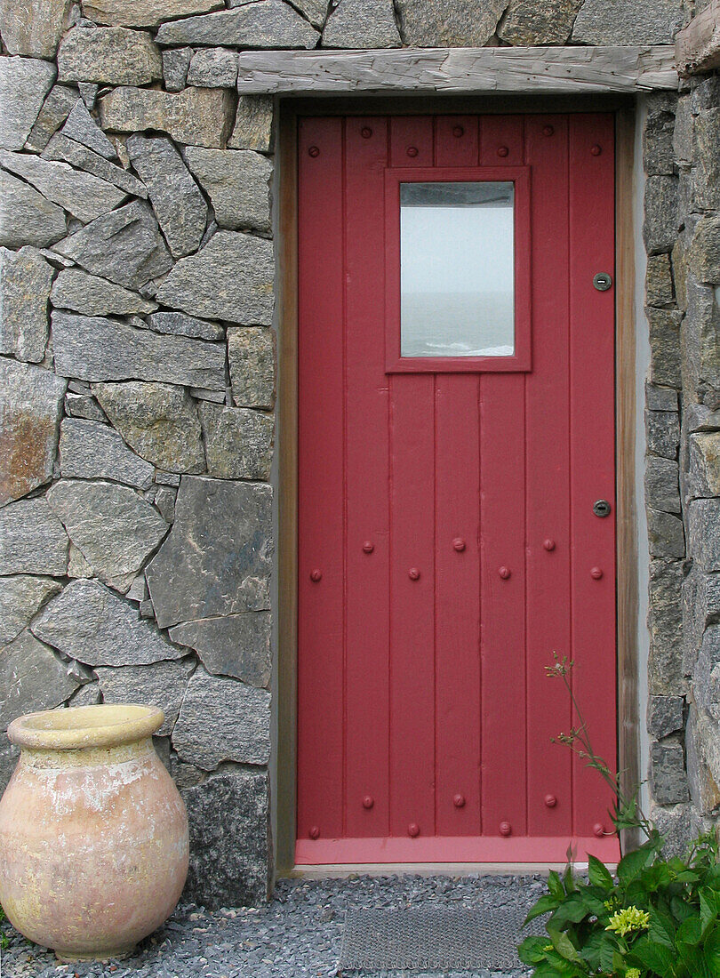Coastal beach house front door set in exposed stone exterior