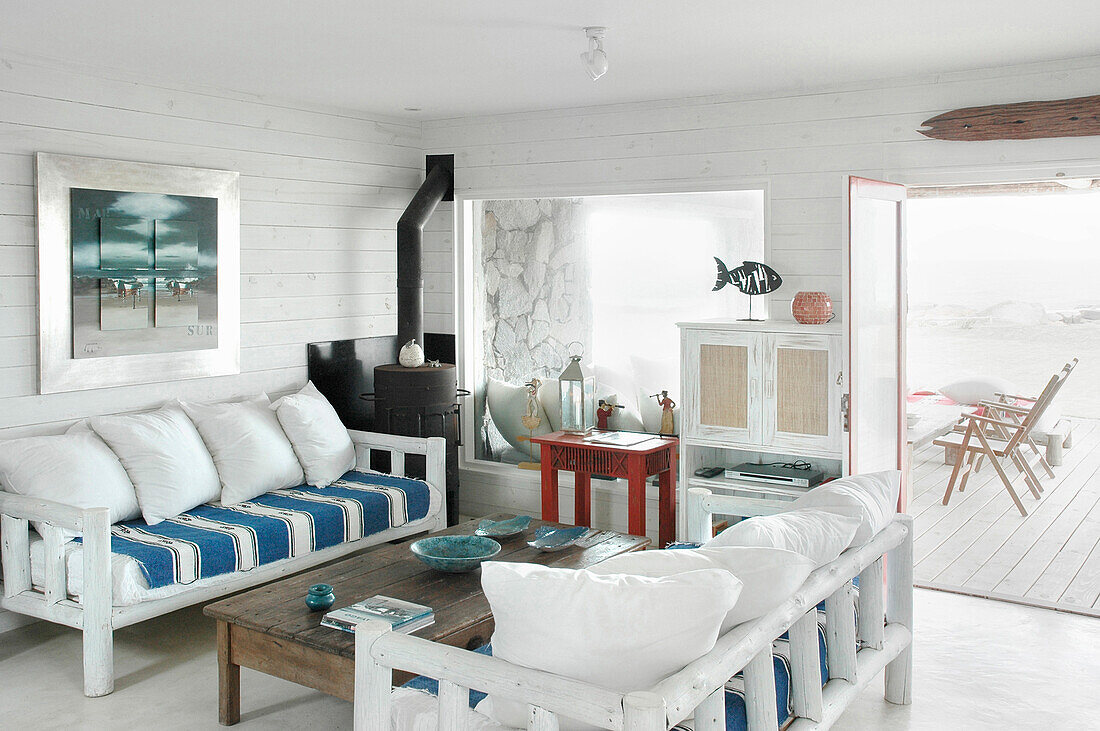 Seating area in beach house with open door to patio area
