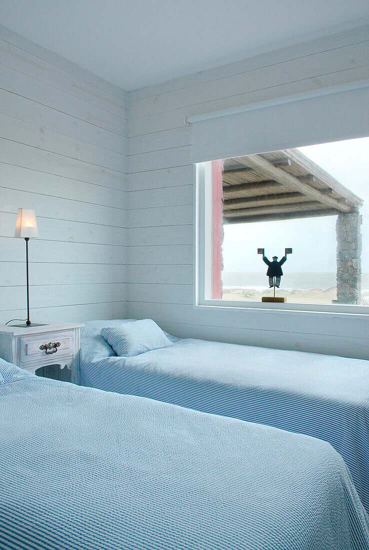 Twin beds and window of coastal beach house